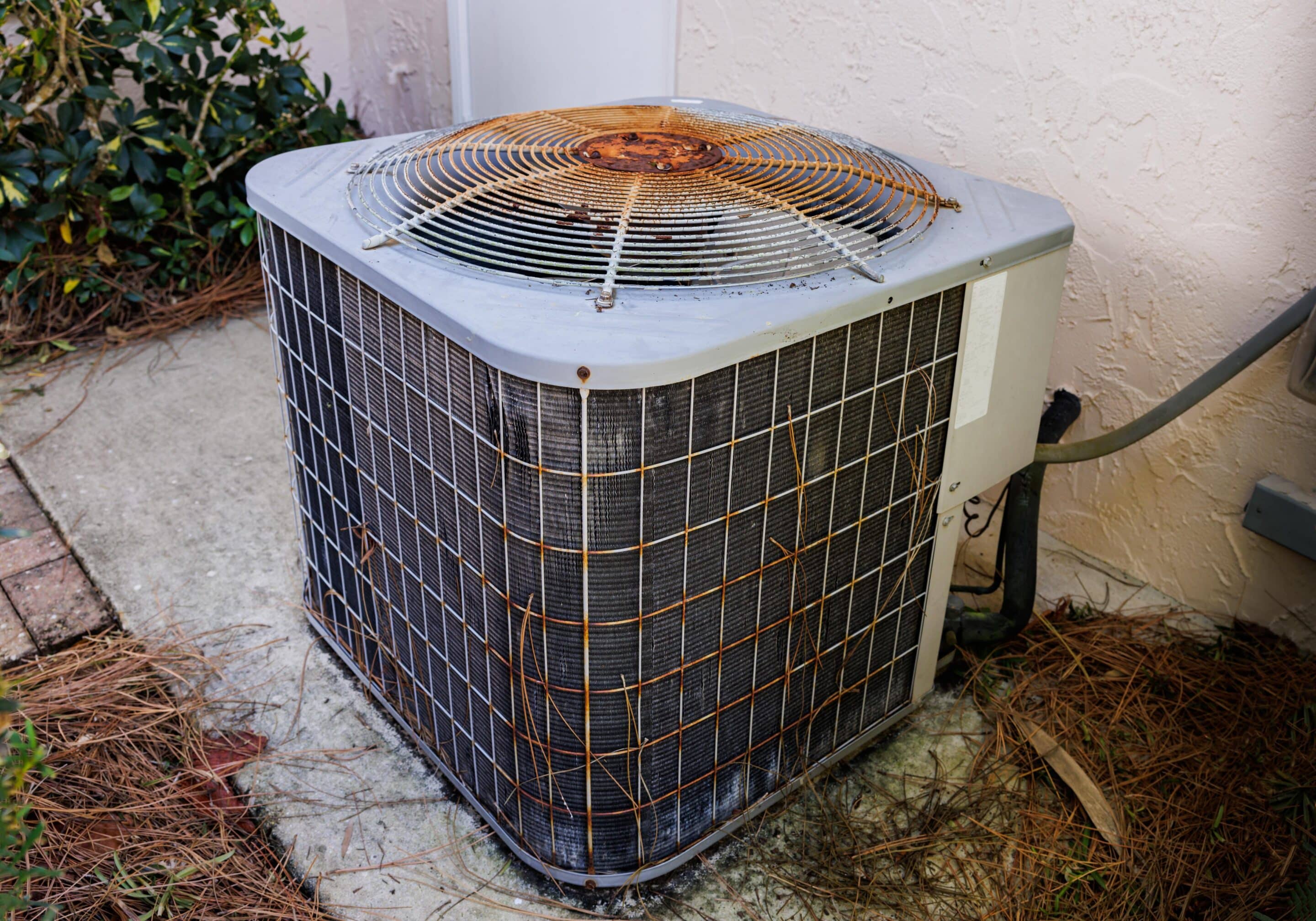 Older residential air conditioner showing signs it may need replacement